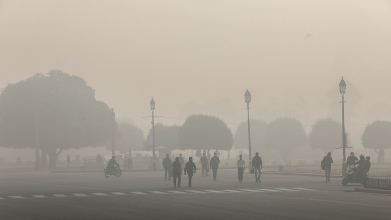 oameni pe strada in new delhi oras acoperit de poluare