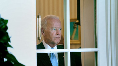 Joe Biden se uită printr-o fereastră la Casa Albă