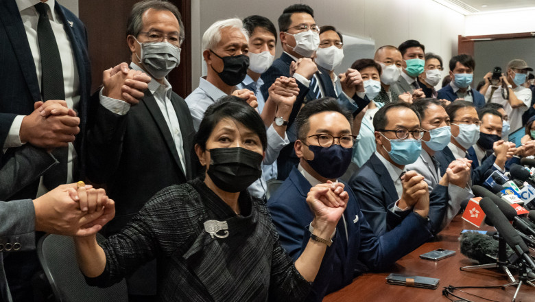 membri ai partidului democratic din hong kong se tine de maini la o conferinta de presa