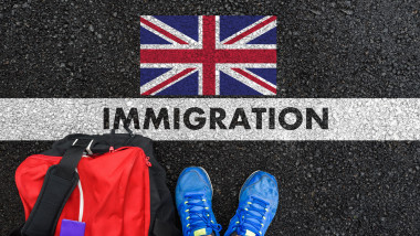 o persoana cu pantofi albastri si valia rosie in fata unui mesaj pentru imigratie in marea britanie-imagine generica