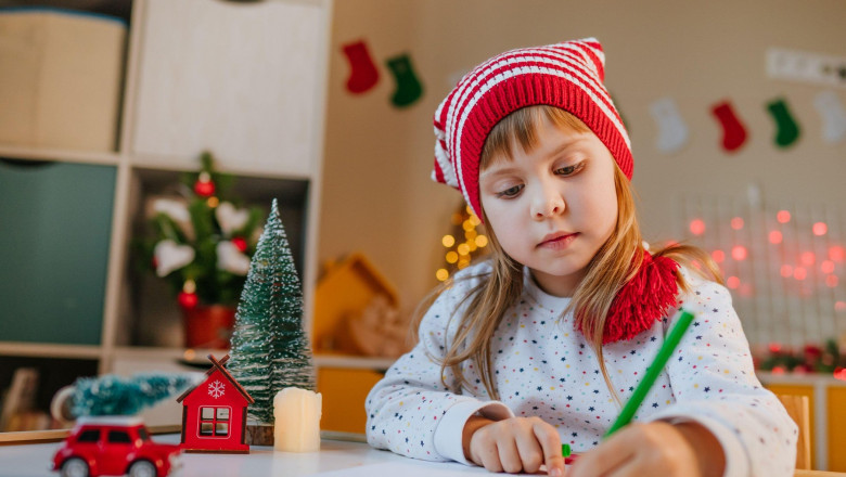 O fetiţă scrie o scrisoare pentru Moş Crăciun