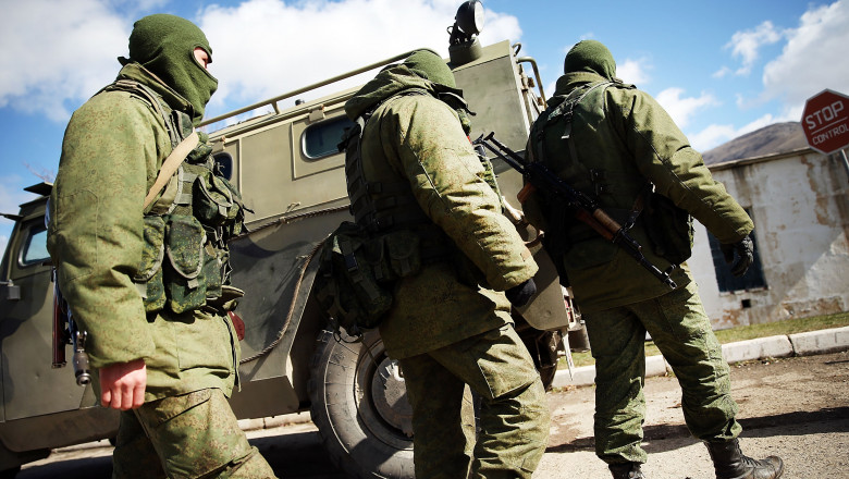 Soldați înarmați fără însemne de identificare păzesc o bază militară din orașul ucrainean Perevevalne de lângă orașul Simferopol din Peninsula Crimeea în martie 2014