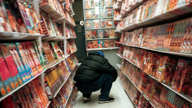 Magazin pentru adulţi în New York, client se uită la rafturile pline cu DVD-uri şi filme porno
