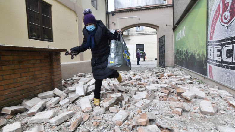 femeie care alearga printre molozul provocat de un cutremur in croatia