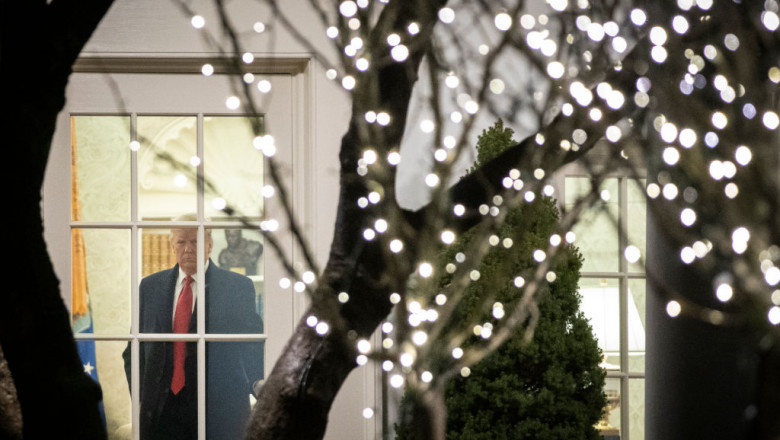 Donald Trump în palton, în Biroul Oval de la Casa Albă, se pregăteşte să plece