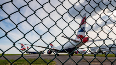 Seen through a wire fence, British Airways aeroplanes are parked at Cardiff Airport whilst unused during the Covid-19 crises.