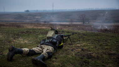 militar culcat cu arma in. pozitie de tragere in donbas, ucraina