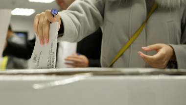 persoana introduce buletinul de vot in urna