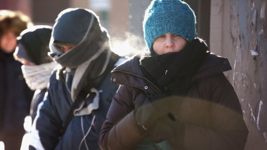 doi oameni pe strada care ingheata de frig