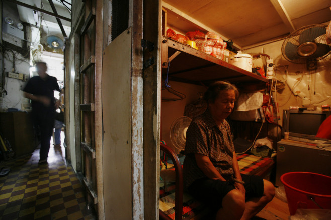 A woman sits inside her "cubicle" home in Hong Kong