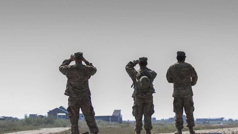 militari români se uită în zare în timpul exercițiului NATO Saber Guardian