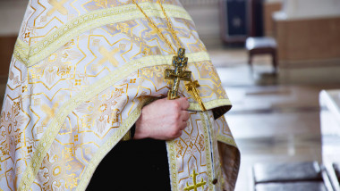 preot ortodox cu crucea in mana