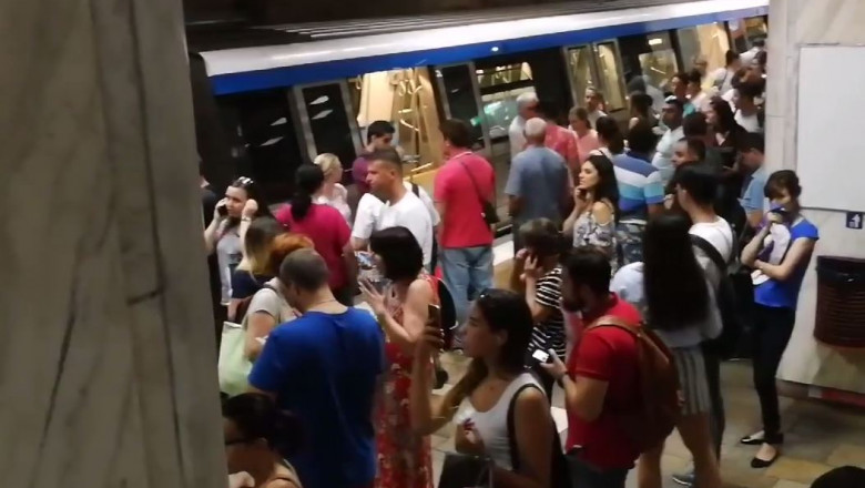 Oamenii așteaptă metroul pe peron
