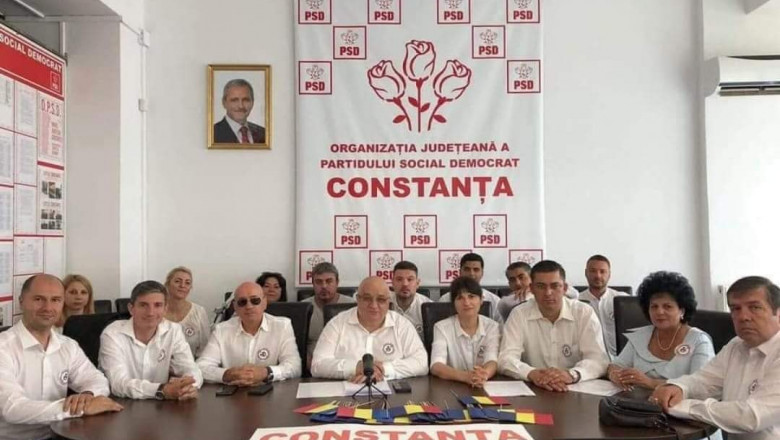 Membrii PSD Constanța, la o sedință în care pe perete apare un tablou cu Liviu Dragnea.