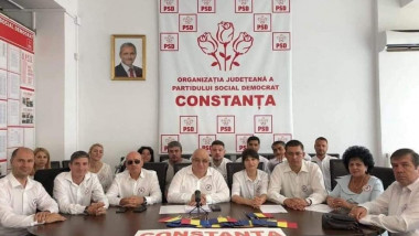 Membrii PSD Constanța, la o sedință în care pe perete apare un tablou cu Liviu Dragnea.