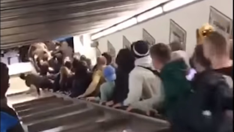 Oameni pe scarile rulante de la metrou