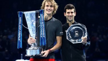 Alexander Zverev și Novak Djokovic, cu trofeele în mână, pe podiumul de premiere după finala Turneului Campionilor 2018, pe arena O2 din Londra