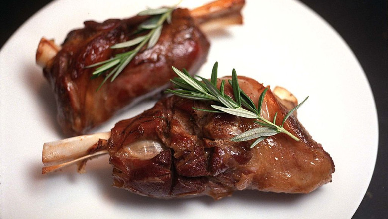 Lamb shanks with rosemary garnish.