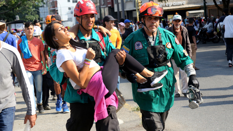 femeie ranita in protestele din venezuela este ajutata de paramedici