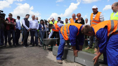 Liviu Dragnea, Olguta Vasilescu si Claudiu Manda se uita la doi muncitori care instaleaza borduri