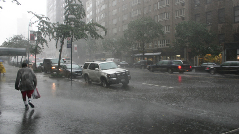 Road with cars in stormy weather people running