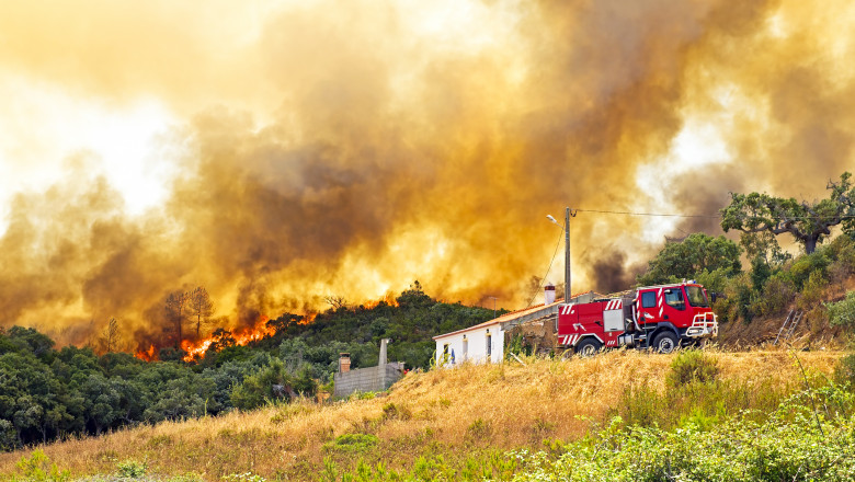 Forest fire near a rural home and fire truck in Portugal
