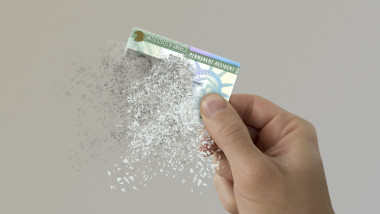 USA green card disintegrates in a man's hand.