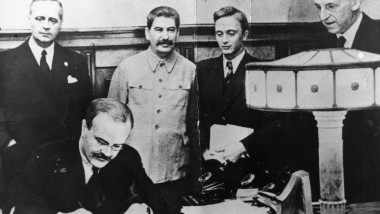 Pactul Ribbentrop-Molotov, semnare. 23 august 1939: Viaceslav Molotov, ministrul rus de externe, semnează Pactul negociat de Rusia sovietică și Germania nazistă, la Kremlin. În spatele lui stau omologul german, Joachim von Ribbentrop (stânga), și liderul sovietic Iosif Stalin (centru)