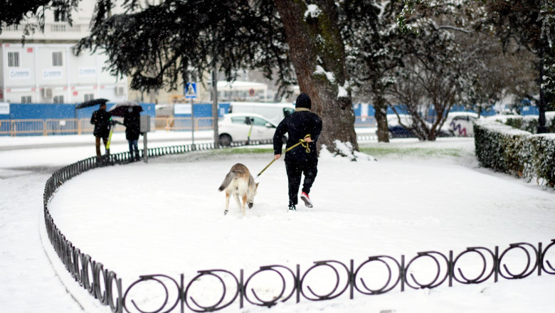Un spaniol își plimbă câinele în Madrid, după furtuna Filomena.