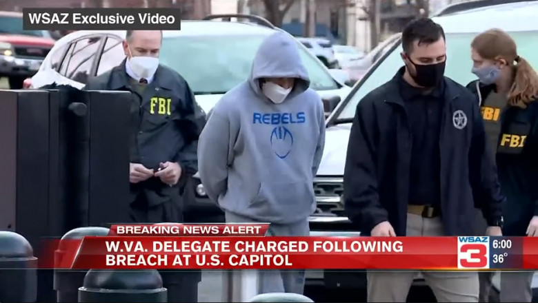 Derrick Evans, cu mainile legate si gluga pe cap,arestat de agenții FBI.