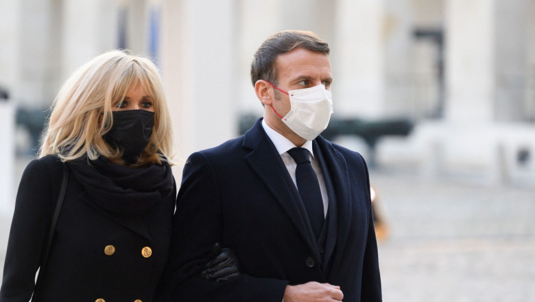 Brigitte și Emmanuel Macron cu masca mergand de brat
