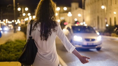 O prostituată face semn mașinilor aflate în trafic.