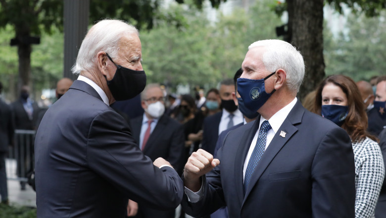 Mike Pence și Joe Biden se salută în cadrul unui eveniment de comemorare a victimelor atacului de la 11 septembrie 2001.