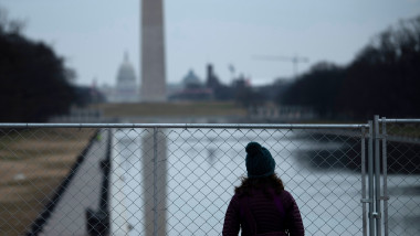 o femeie se uita dupa un gard de sarma la esplanada national mall din washington dc