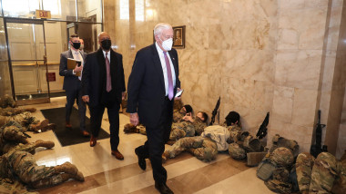 Membri ai Camerei Reprezentanţilor SUA merg printre soldaţi ai Gărzii Naţionale care dorm pe podelele Congresului SUA