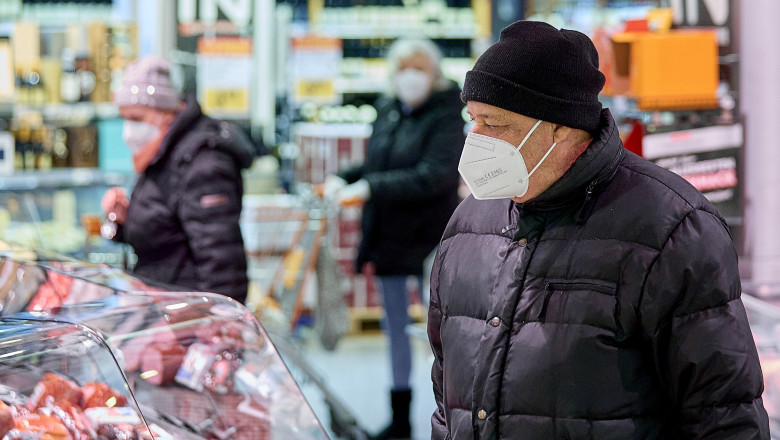 oameni purtand masca ffp2 intr-un market din viena