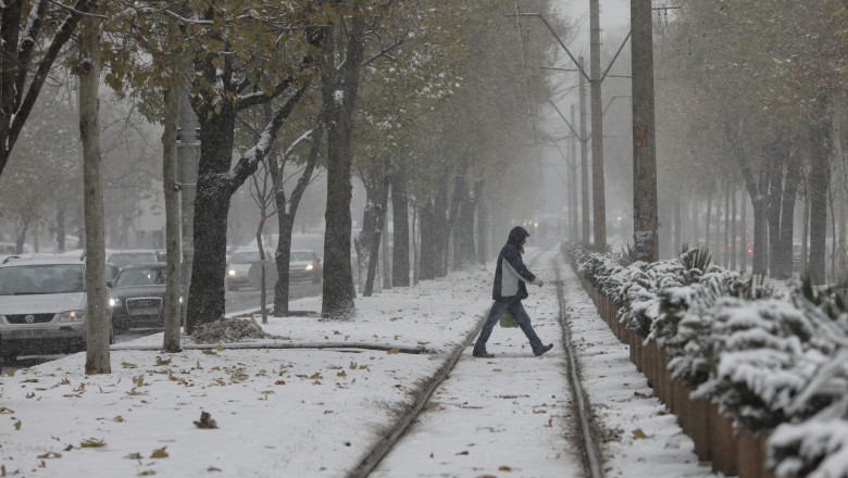 un om traverseaza sina de tramvai iarna