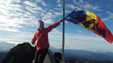 Alpinista Dor Geta Popescu. Foto: Facebook/Dor Geta Popescu flutură steagul României pe vârful unui munte