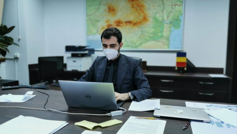 Ministrul Economiiei, Claudiu Năsui, este fotografiat in birou, lucrand la laptop si purtand masca de protectie