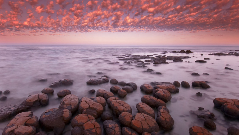Grup de roci cu stromatoliți pe malul oceanului în Australia, la apusul Soarelui
