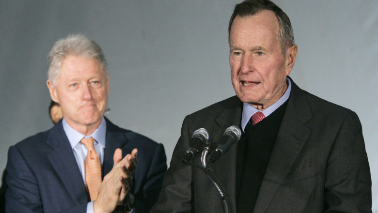 Fostul președinte Bill Clinton (stânga) îl aplaudă pe fostul președinte George Bush senior, la 7 decembrie 2005, la o ceremonie în New Orleans