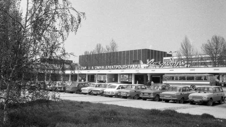 imagine alb negru de epoca cu intrarea in uzina nucleara de la kozlodui, in fata careia sunt parcate masini rusesti