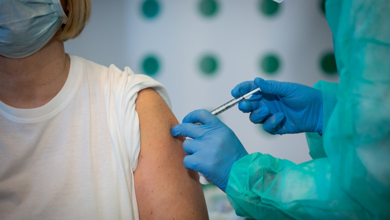 O femeie este vaccinată împotriva COVID-19.