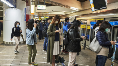 oameni din taiwan asteapta la coada la metroul din taipei.