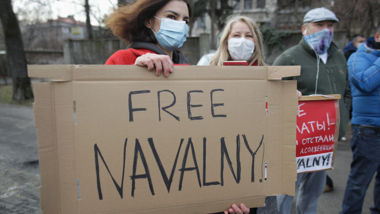 o femeie tine o pancarta cu eliberati-l pe navalni iin fata ambasadei rusiei la bucuresti,alaturi de cativa protestatari