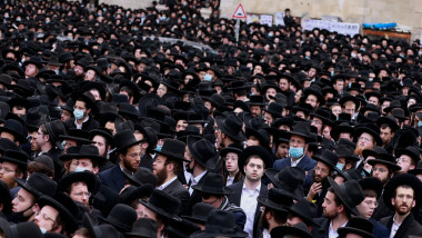 mii de evrei ultraortodocsi stau inghesuiti pe strazi la procesiunea de inmormantare a unui rabin