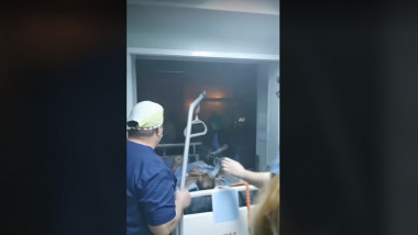 un pacient in pat este evacuat de cadre medicale dintr-un salon plin de fum