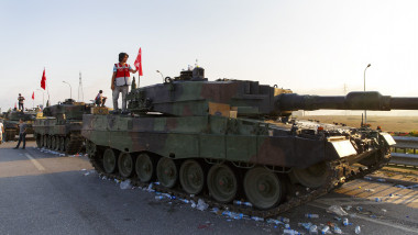 barbat sta pe un tanc cu steagul turciei