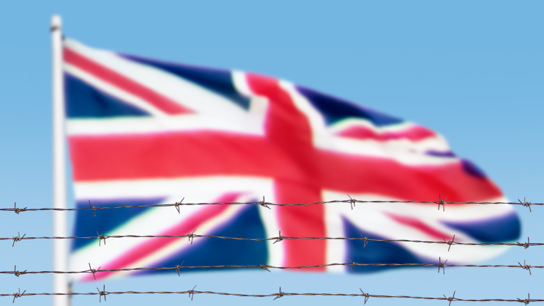 steagul marii britanii flutura in spatele unui gard de sarma ghimpata