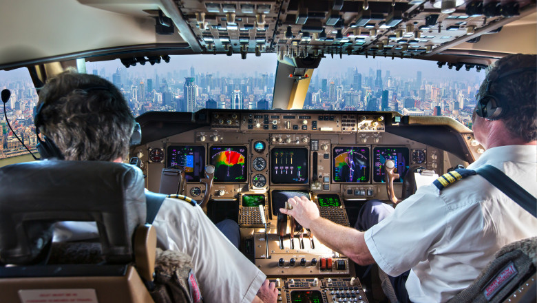 piloti in cabina de pilotaj a unui avion inainte de aterizare